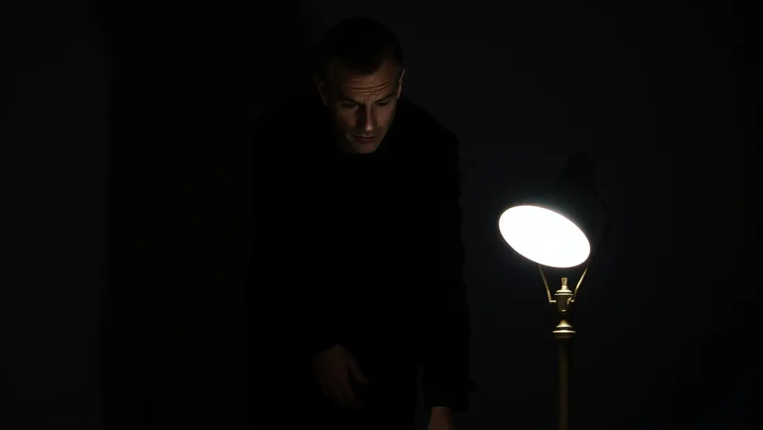 Hombre en negro en una habitación oscura